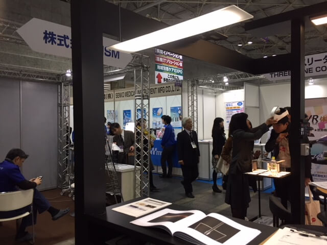crowded Taiyo booth at Medical Japan showing OLED fixtures