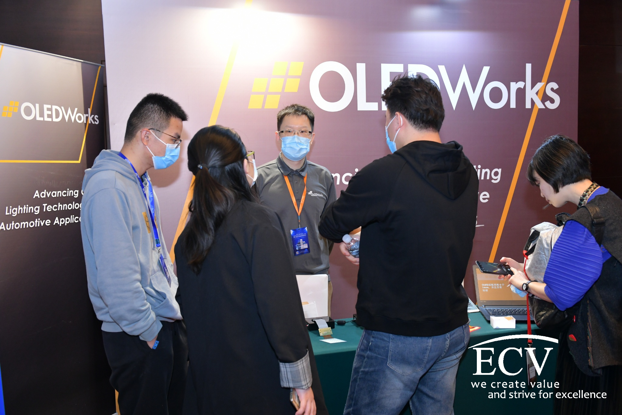 Attendees visit the OLEDWorks booth