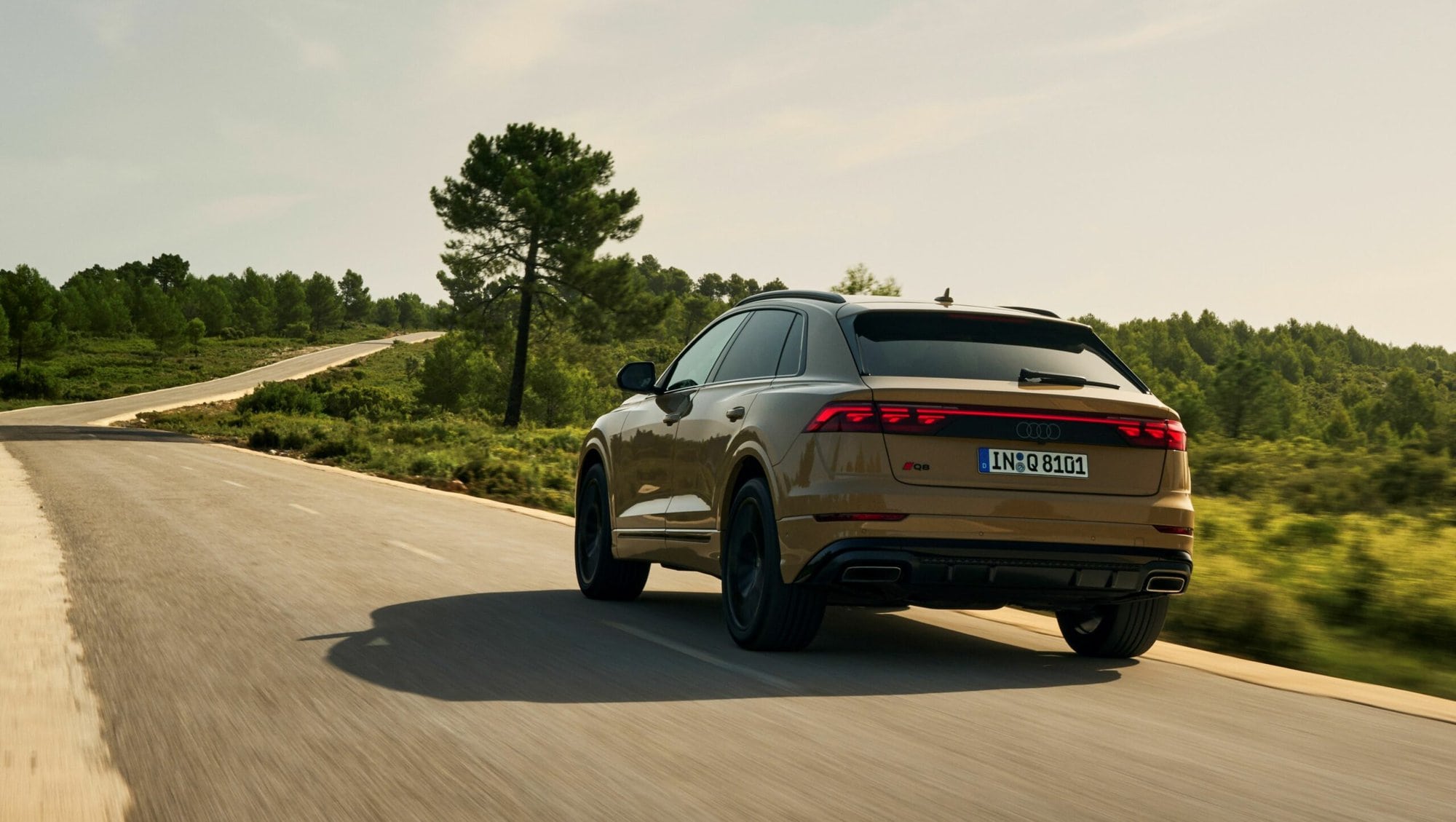 Gold Audi Q8 on the road with digital Atala OLED rear lighting.